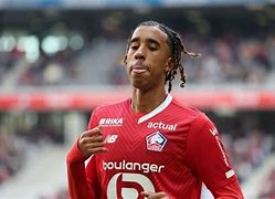 Leny Yoro disputando un balón aéreo con el Manchester United